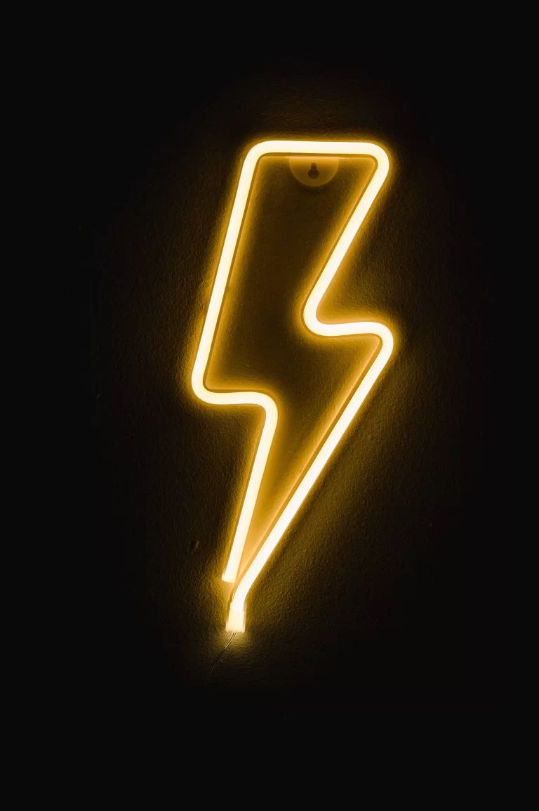 Neon lighting bolt with dark background.