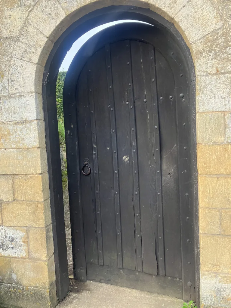 An open rounded door in a wall.