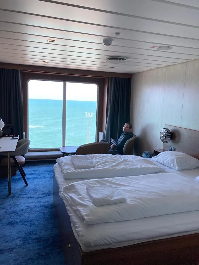 Rose sitting in the Nordic deluxe cabin with a queen bed.
