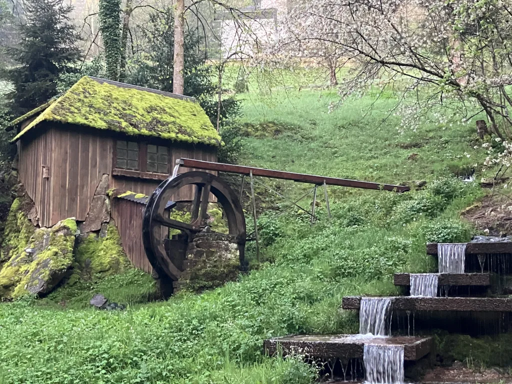 water mill and stream with green background.
