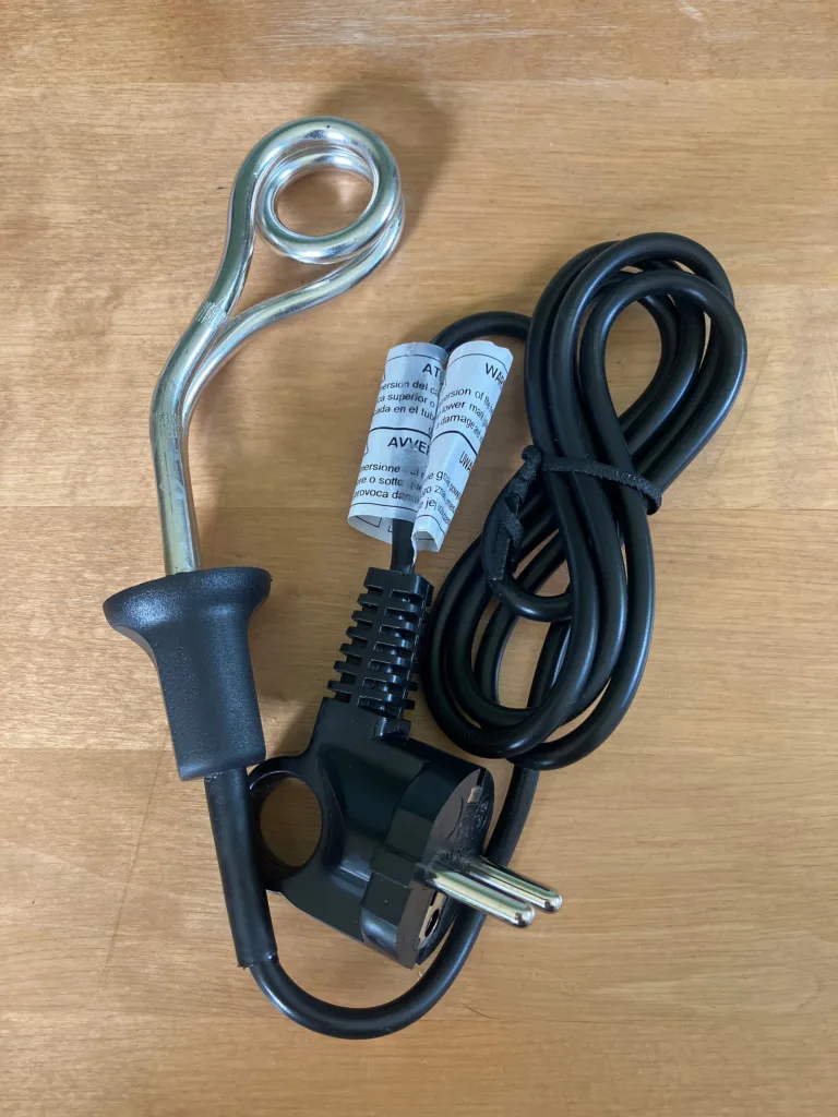 black corded coil water heater on wooden table.